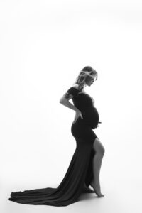 Classic side profile maternity image with studio lighting highlighting the baby bump