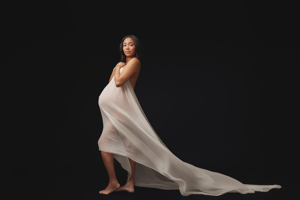 Maternity portrait of a pregnant woman with flowing fabric captured in a Maryland photography studio