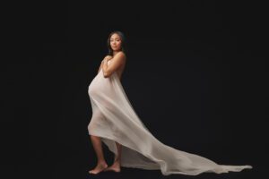 Maternity portrait of a pregnant woman with flowing fabric captured in a Maryland photography studio
