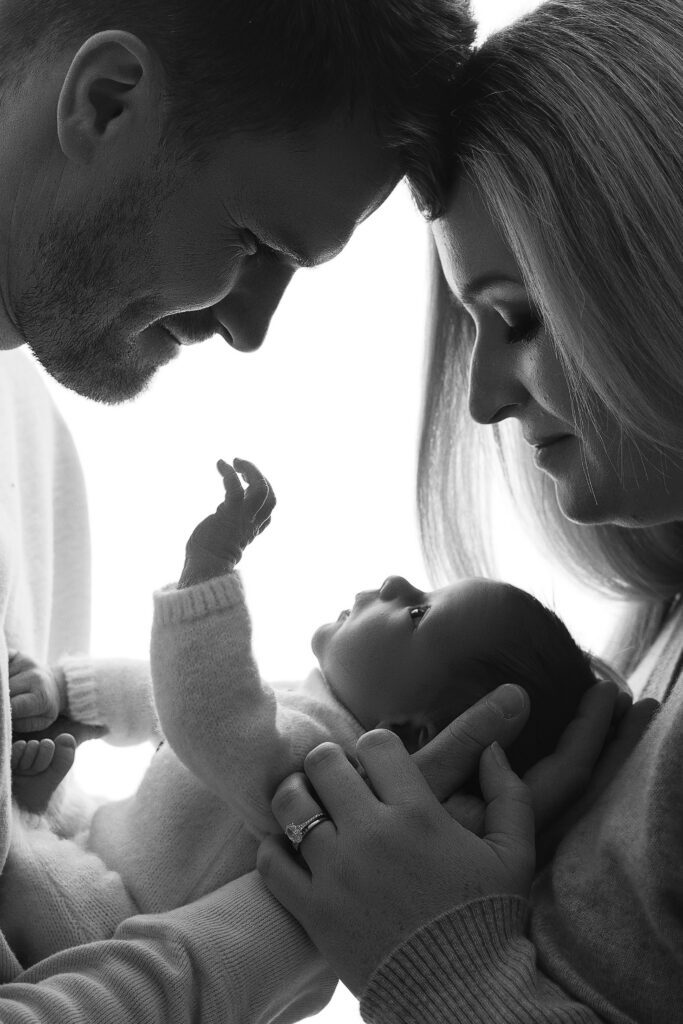 Black and white portrait of parents holding their newborn baby photographed in a Baltimore newborn photography studio